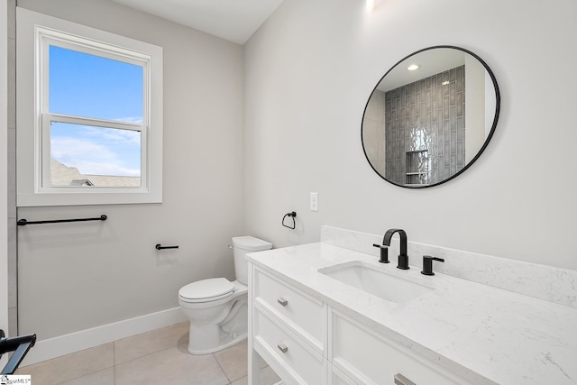 bathroom featuring toilet, tile patterned flooring, vanity, and baseboards