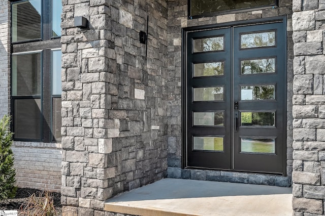 entrance to property featuring stone siding and french doors