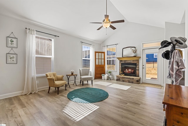 sitting room with lofted ceiling, a fireplace, light wood-style flooring, and ceiling fan