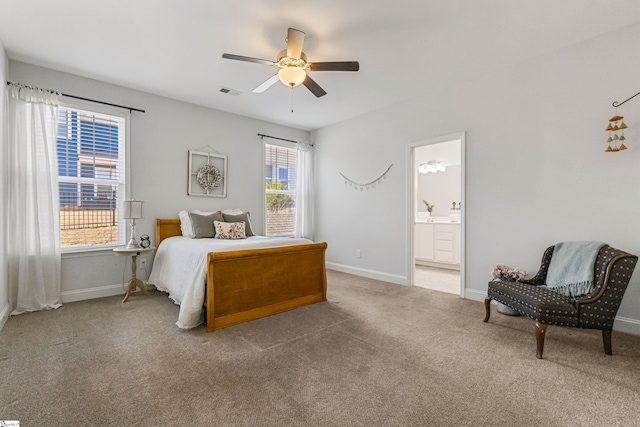 carpeted bedroom featuring baseboards, visible vents, a ceiling fan, and ensuite bathroom