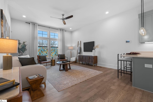 living area with baseboards, a ceiling fan, wood finished floors, and recessed lighting