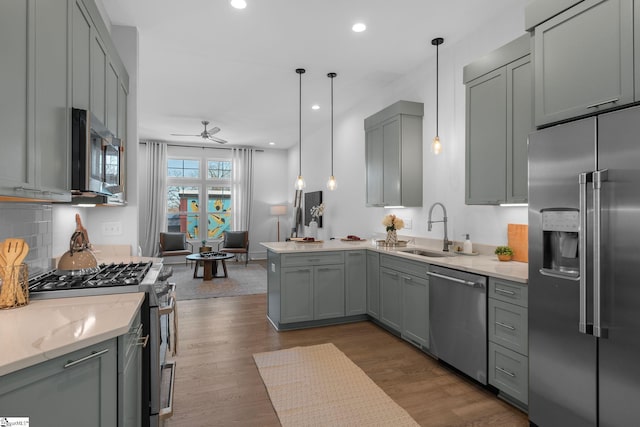 kitchen with dark wood-type flooring, appliances with stainless steel finishes, gray cabinets, and a sink