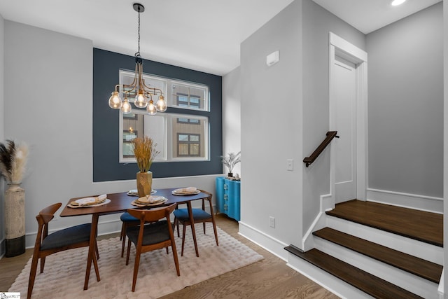 dining area with a chandelier, wood finished floors, and baseboards