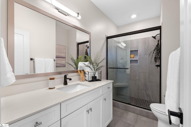 full bathroom with a stall shower, vanity, toilet, and tile patterned floors