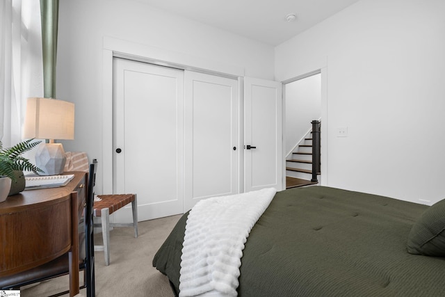 bedroom featuring light carpet and a closet