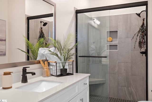 bathroom with tiled shower and vanity