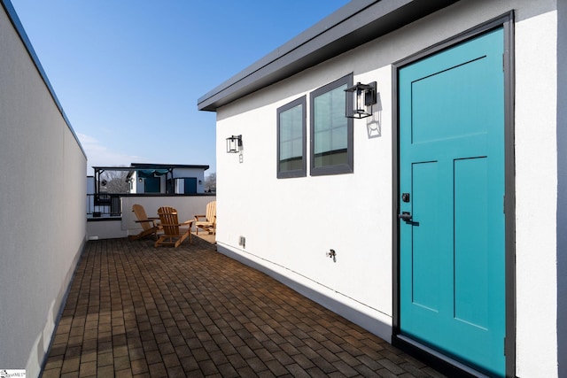 property entrance with a patio area and stucco siding