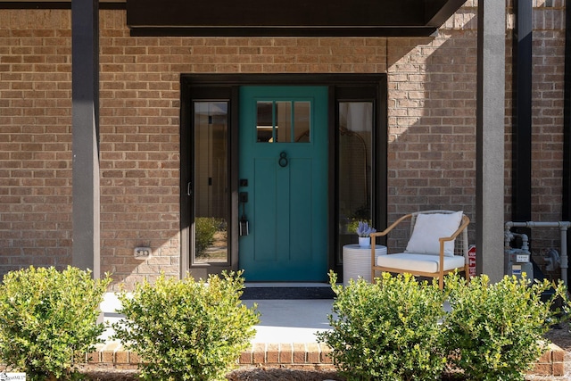 doorway to property with brick siding