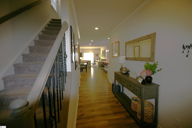 hall featuring recessed lighting, crown molding, stairway, and wood finished floors