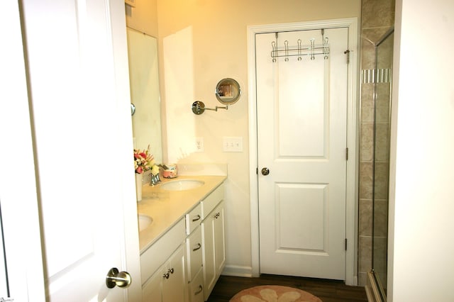 full bath with double vanity, an enclosed shower, and a sink