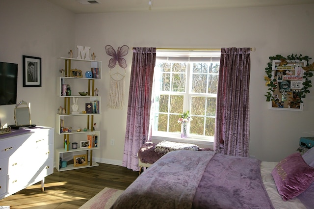 bedroom featuring multiple windows, visible vents, and wood finished floors