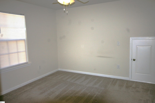 empty room with ceiling fan, baseboards, and light colored carpet