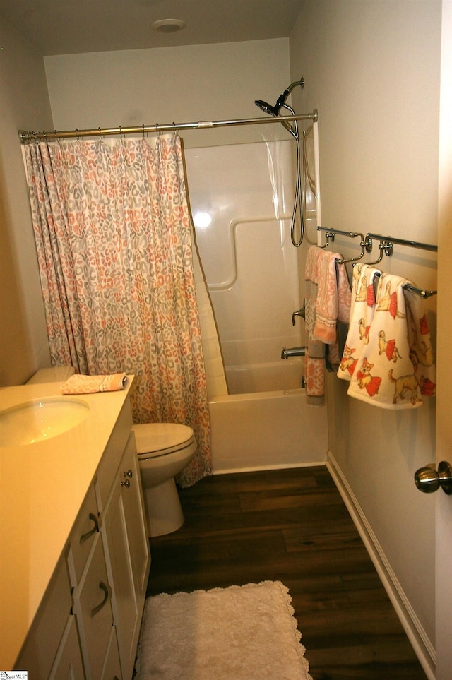 bathroom with toilet, shower / bath combo with shower curtain, vanity, wood finished floors, and baseboards