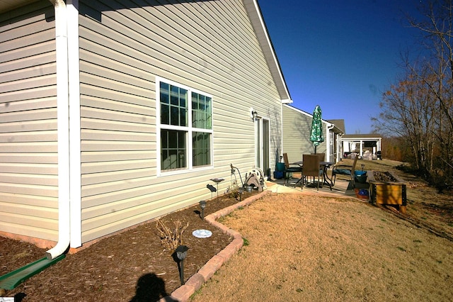 view of property exterior with a yard and a patio