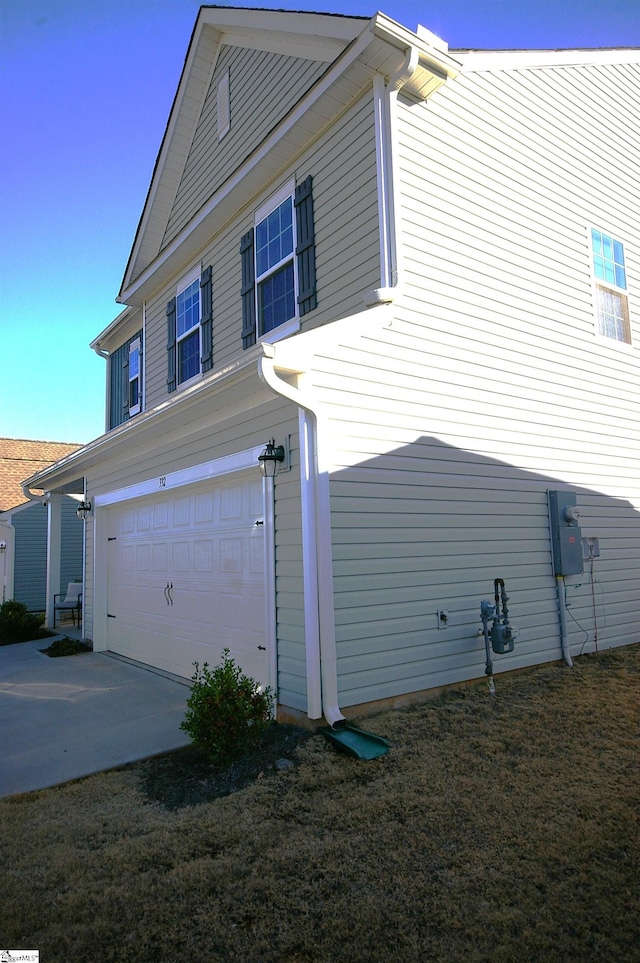 view of side of home with a garage and concrete driveway