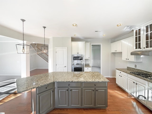 kitchen with white cabinets, under cabinet range hood, stainless steel appliances, and gray cabinetry