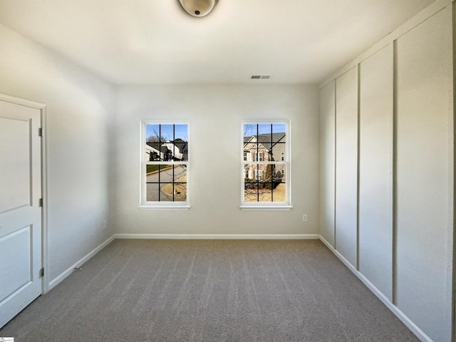 unfurnished bedroom with carpet floors, visible vents, and baseboards