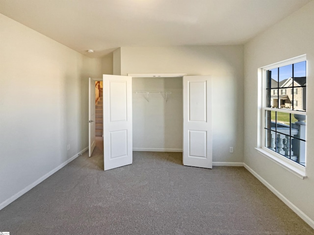 unfurnished bedroom with carpet floors, a closet, and baseboards