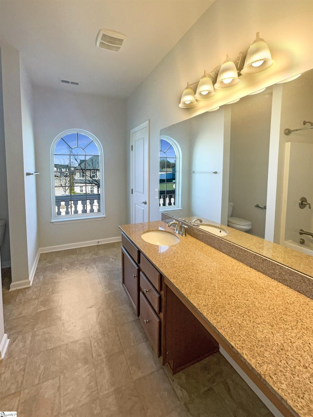 bathroom featuring visible vents, vanity, toilet, and baseboards