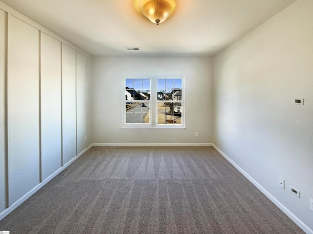 unfurnished room with carpet, visible vents, and baseboards