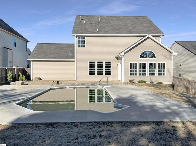 rear view of house with a patio, fence, and a fenced in pool