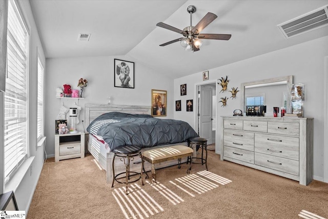 bedroom featuring lofted ceiling, ceiling fan, visible vents, and light colored carpet