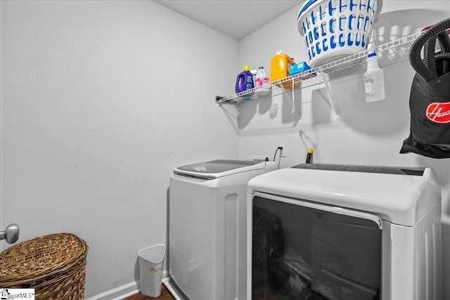 clothes washing area featuring laundry area, baseboards, and washer and dryer