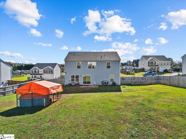 back of house featuring a fenced backyard, a residential view, and a lawn