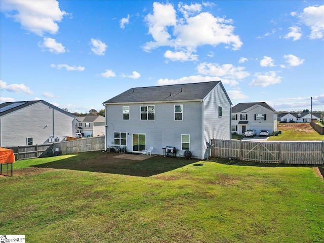 back of house featuring a residential view, a fenced backyard, and a yard