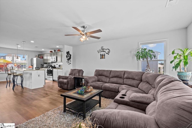 living room with a ceiling fan, light wood-type flooring, and recessed lighting