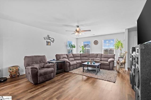 living area with ceiling fan, baseboards, and wood finished floors