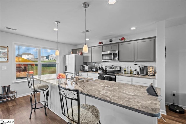 kitchen with visible vents, appliances with stainless steel finishes, decorative backsplash, and a sink