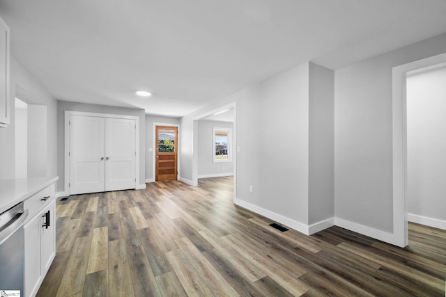 unfurnished room with visible vents, baseboards, and dark wood-style flooring