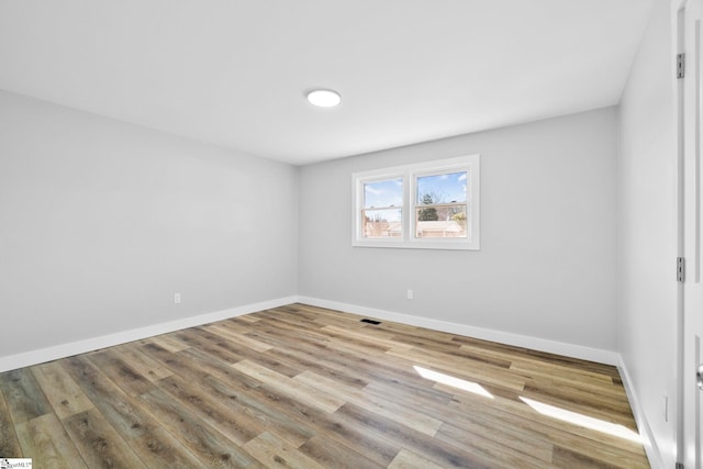 unfurnished room featuring baseboards and wood finished floors