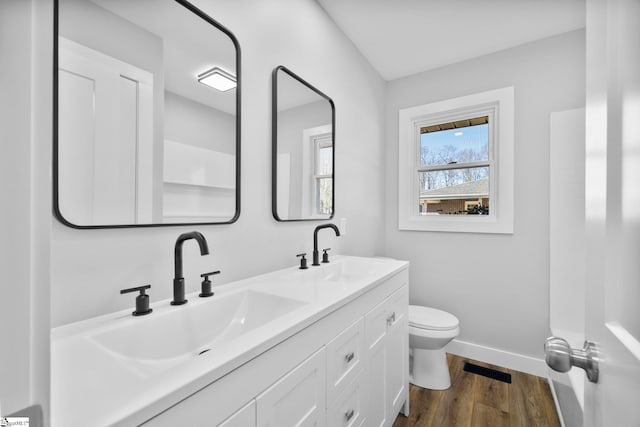 bathroom featuring wood finished floors, a sink, toilet, and baseboards