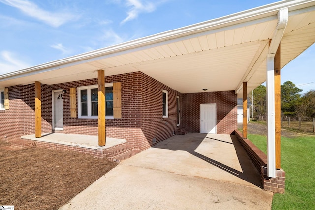 view of patio featuring covered porch, driveway, and a carport