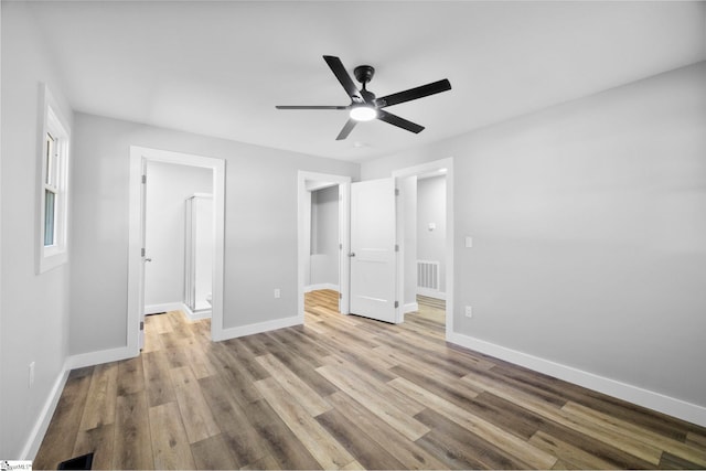 unfurnished bedroom with visible vents, baseboards, ceiling fan, and wood finished floors