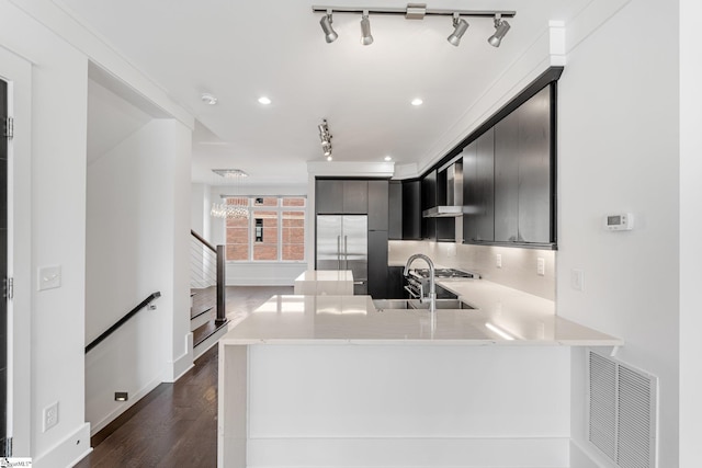 kitchen with light countertops, visible vents, backsplash, a sink, and stainless steel built in refrigerator