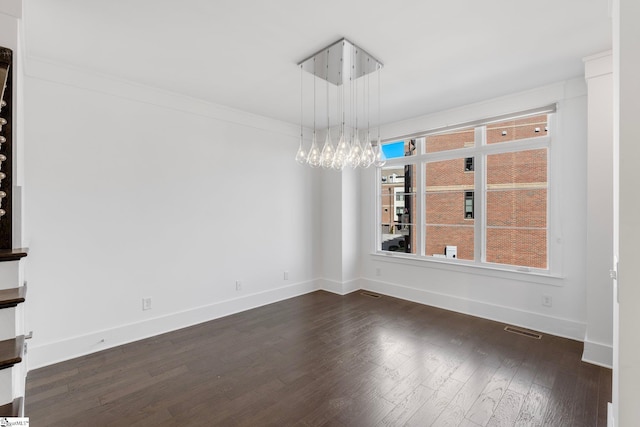 empty room with visible vents, baseboards, dark wood-style flooring, and ornamental molding