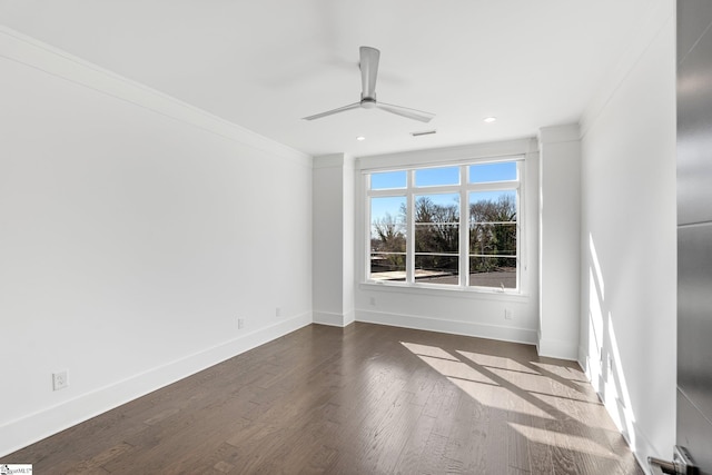 empty room featuring a ceiling fan, crown molding, baseboards, and wood finished floors