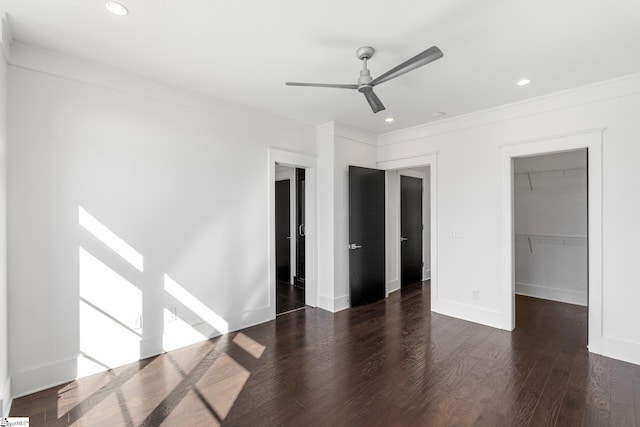 unfurnished bedroom featuring recessed lighting, a closet, a spacious closet, wood finished floors, and baseboards