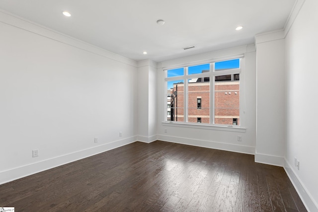 unfurnished room with dark wood-style floors, visible vents, baseboards, and recessed lighting