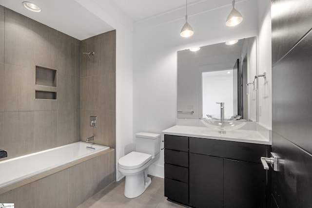 bathroom featuring tiled shower / bath, vanity, and toilet