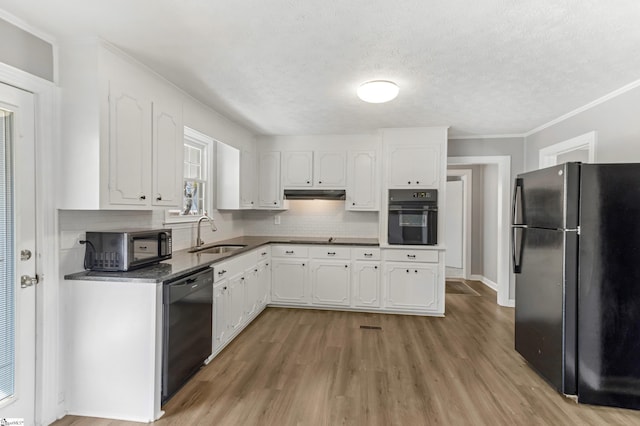 kitchen with black appliances, a sink, white cabinets, and under cabinet range hood