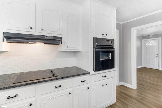 kitchen with ornamental molding, white cabinets, under cabinet range hood, and black appliances