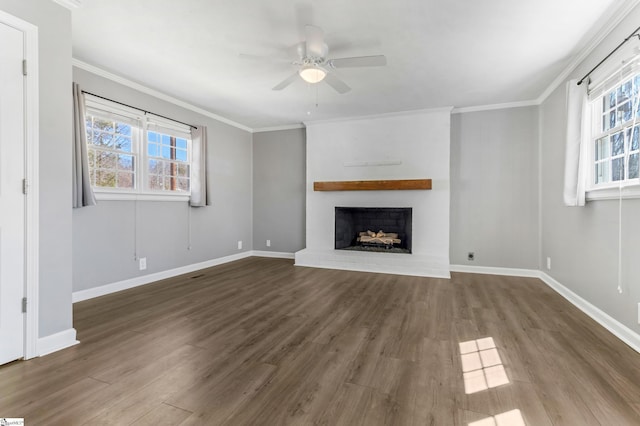 unfurnished living room with a fireplace, crown molding, and wood finished floors