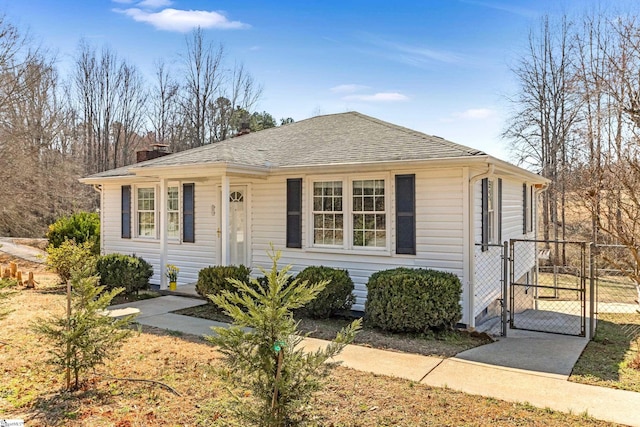 bungalow-style home featuring roof with shingles, a chimney, fence, and a gate