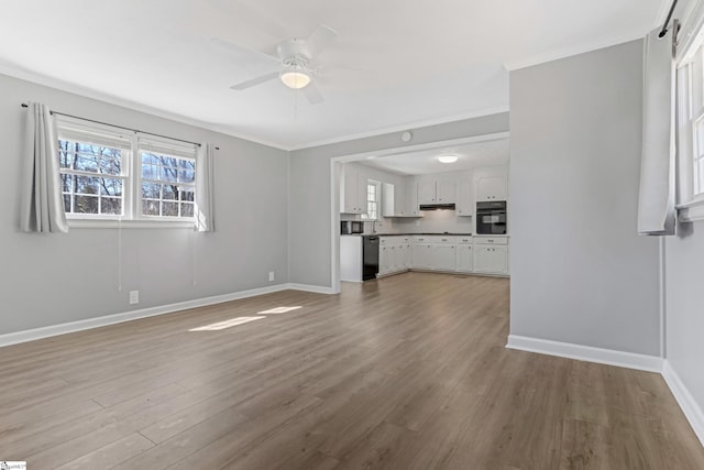 unfurnished living room with ceiling fan, baseboards, wood finished floors, and ornamental molding