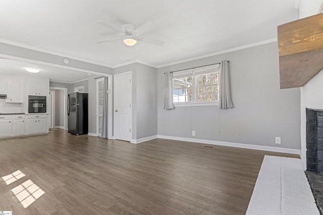 unfurnished living room with a brick fireplace, crown molding, baseboards, and dark wood-style flooring