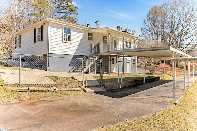 manufactured / mobile home featuring a fenced front yard, stairway, driveway, and a carport